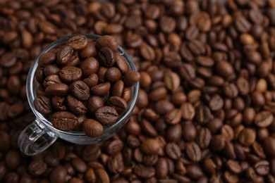 Photo of Aromatic coffee beans and glass cup on table, above view. Space for text