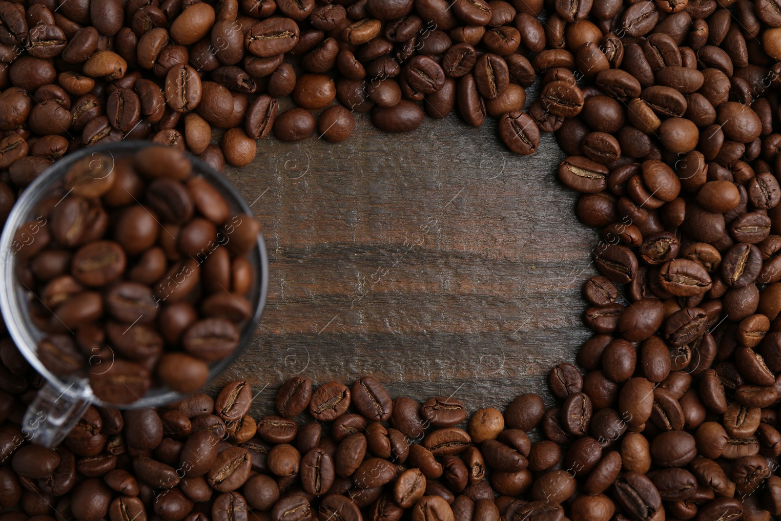 Aromatic coffee beans and glass cup on wooden table, flat lay. Space for text Photo of Aromatic coffee beans and glass cup on wooden table, flat lay. Space for text