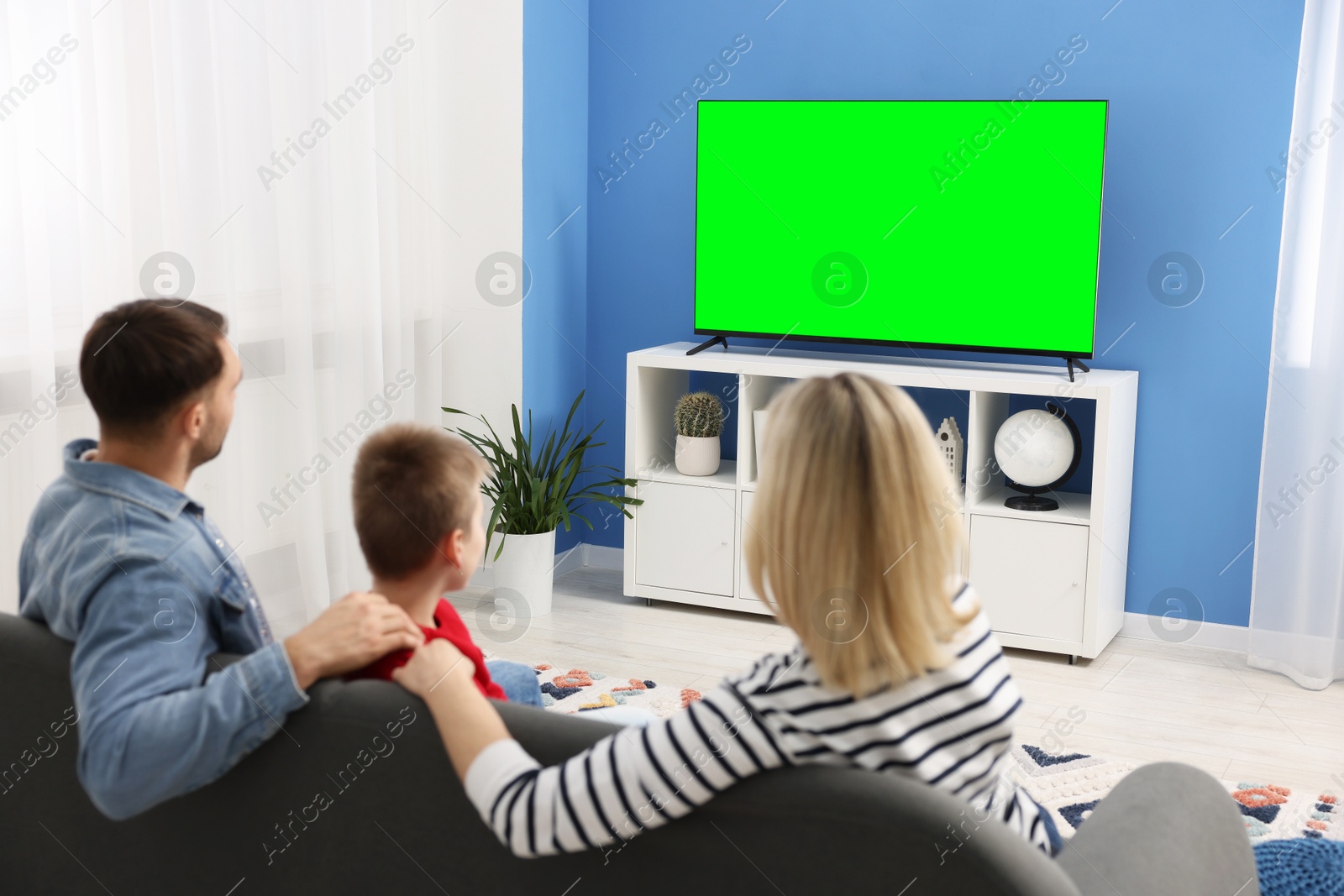 Family watching modern TV set with green screen at home. Chroma key compositing Image of Family watching modern TV set with green screen at home. Chroma key compositing