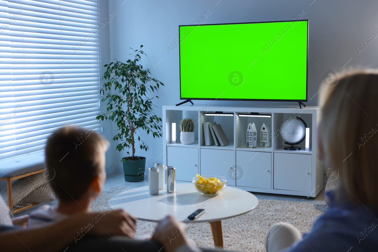 Family watching modern TV set with green screen at home. Chroma key compositing Image of Family watching modern TV set with green screen at home. Chroma key compositing