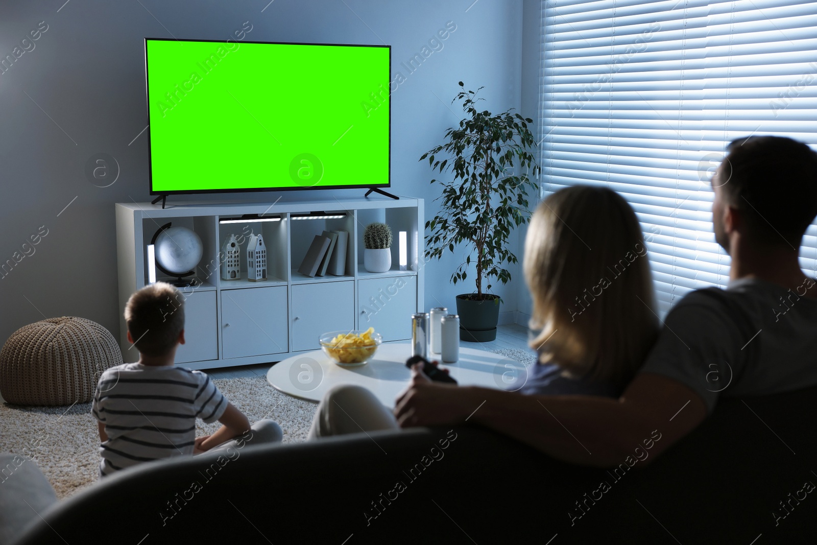Family watching modern TV set with green screen at home. Chroma key compositing Image of Family watching modern TV set with green screen at home. Chroma key compositing