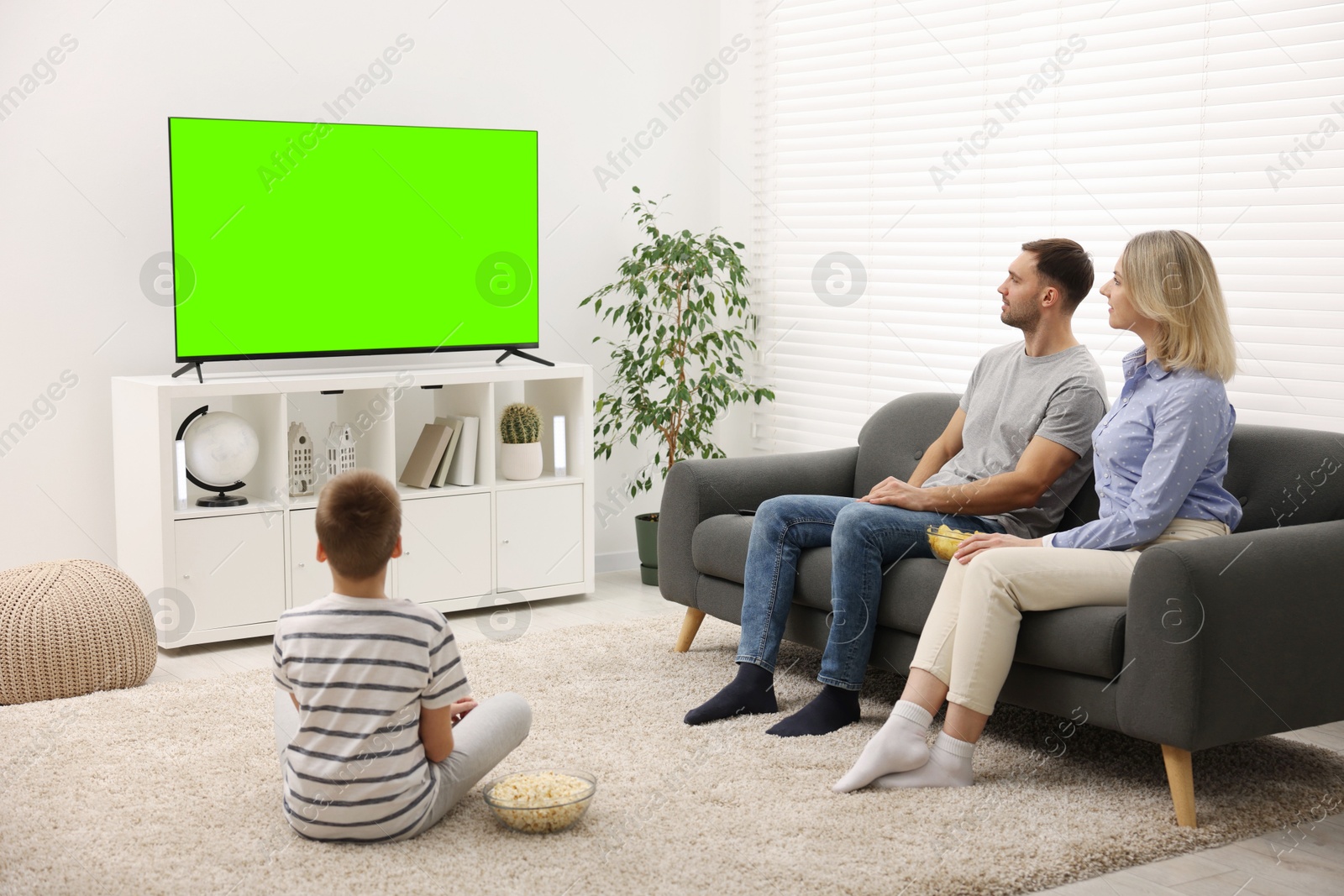 Family watching modern TV set with green screen at home. Chroma key compositing Image of Family watching modern TV set with green screen at home. Chroma key compositing