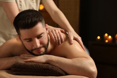 Photo of Man receiving relaxing massage in spa salon