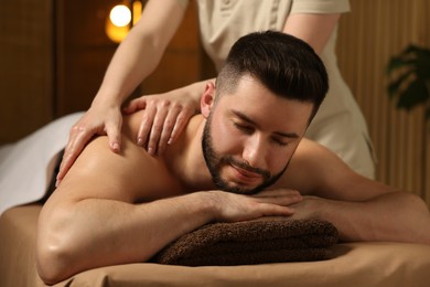 Photo of Man receiving relaxing massage in spa salon