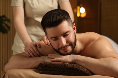 Photo of Man receiving relaxing massage in spa salon