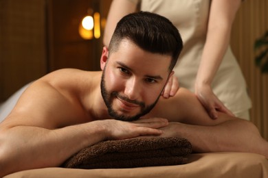 Photo of Man receiving relaxing massage in spa salon