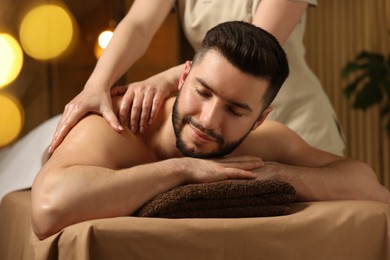 Photo of Man receiving relaxing massage in spa salon