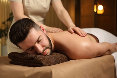 Photo of Man receiving relaxing massage in spa salon