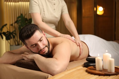 Photo of Man receiving relaxing massage in spa salon