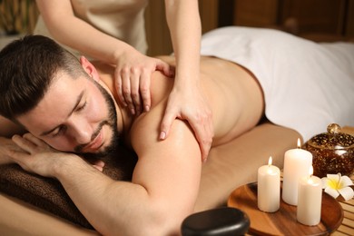 Photo of Man receiving relaxing massage in spa salon