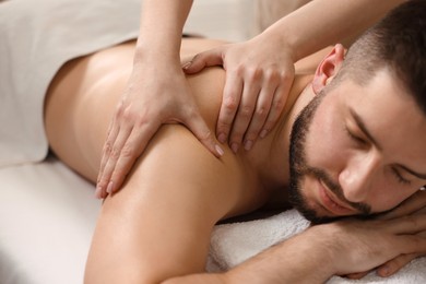 Photo of Man receiving relaxing massage in spa salon