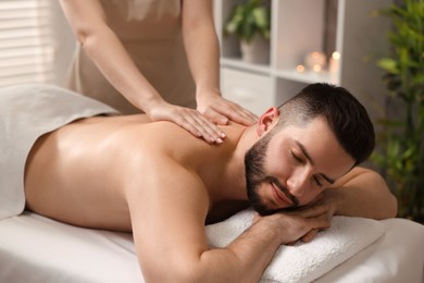 Photo of Man receiving relaxing massage in spa salon