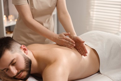 Photo of Man receiving relaxing massage in spa salon