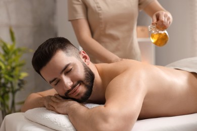 Photo of Man receiving relaxing massage in spa salon
