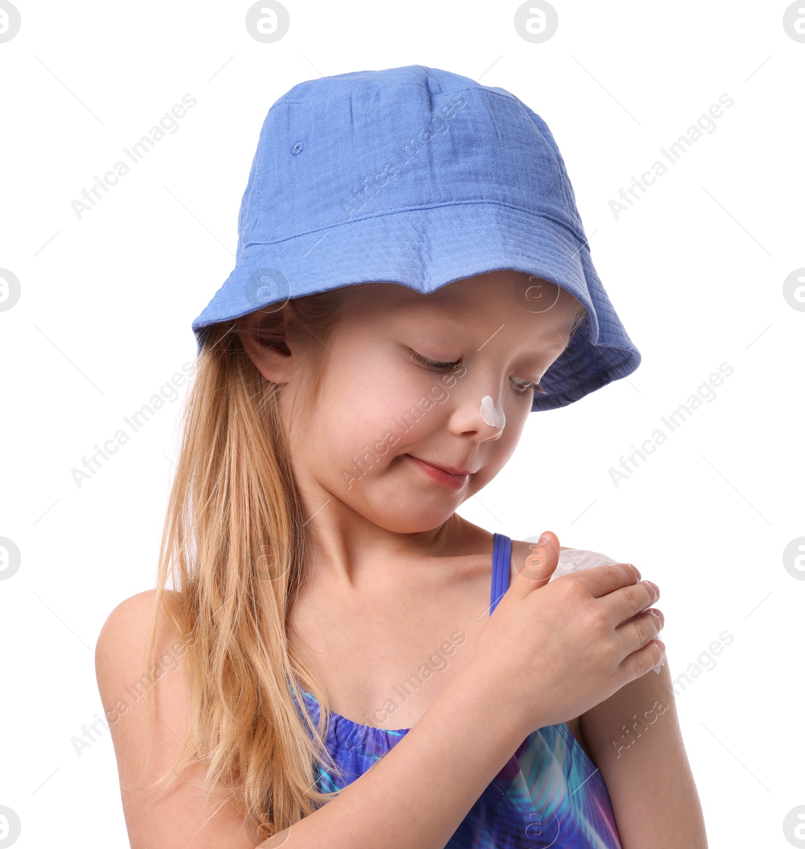 Cute little girl applying sun protection cream onto her shoulder against white background Photo of Cute little girl applying sun protection cream onto her shoulder against white background