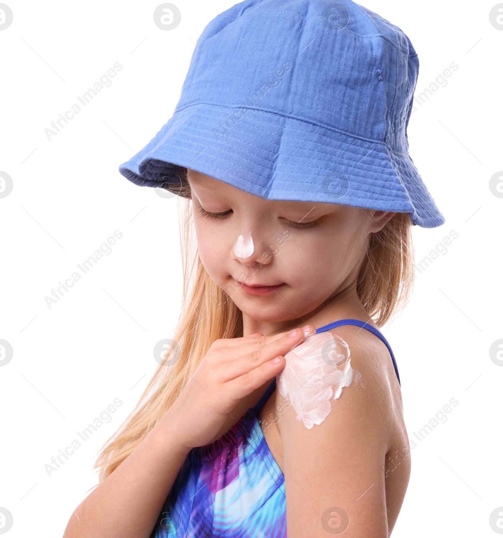 Cute little girl applying sun protection cream onto her shoulder against white background Photo of Cute little girl applying sun protection cream onto her shoulder against white background