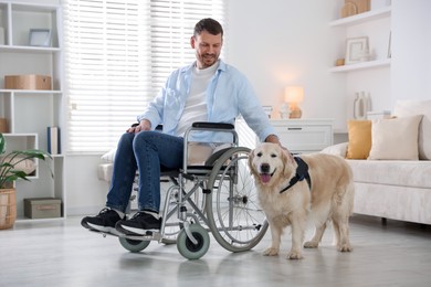 Photo of Man in wheelchair with his service dog at home