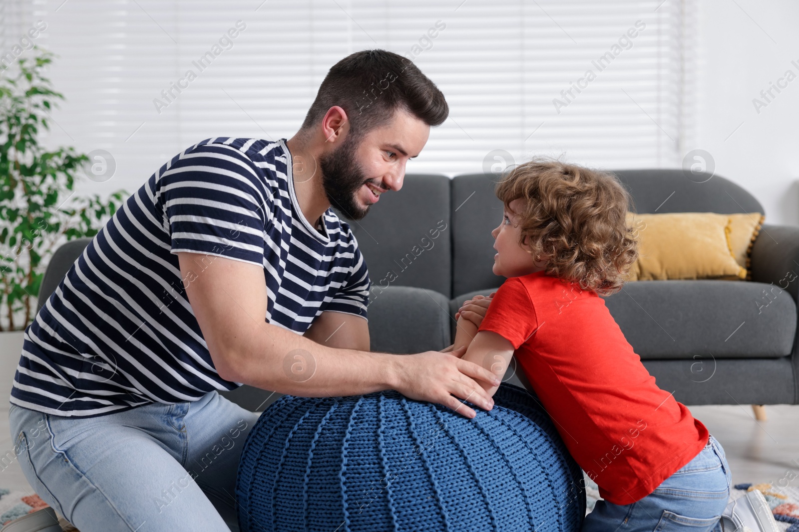 Happy father with his son arm wrestling and spending time together at home Photo of Happy father with his son arm wrestling and spending time together at home