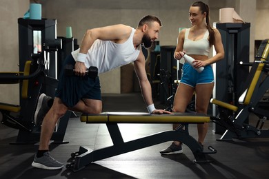 Photo of Athletic man and woman training in gym