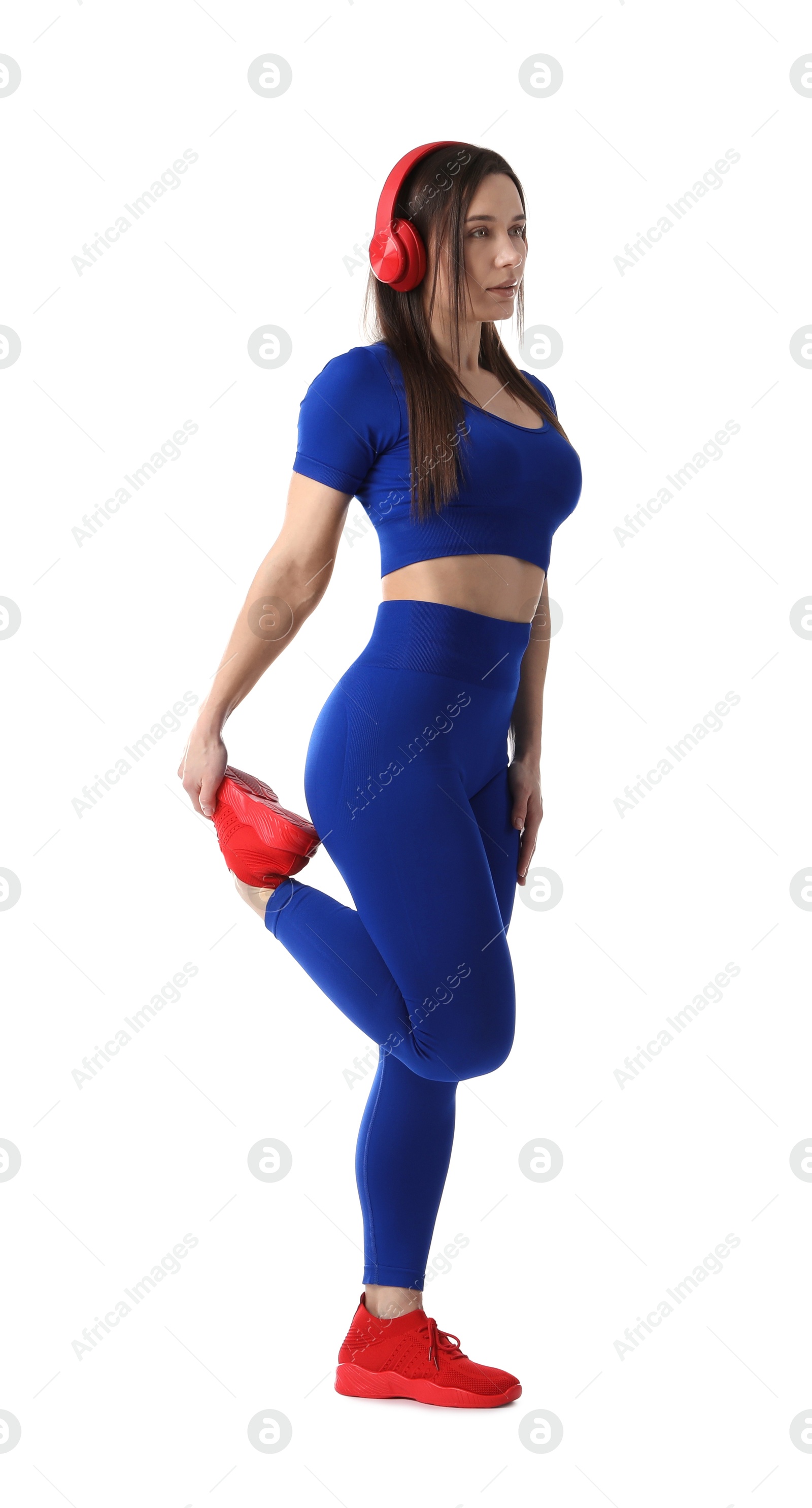 Woman in sportswear with headphones exercising on white background Photo of Woman in sportswear with headphones exercising on white background