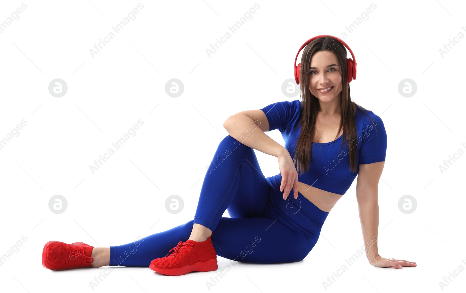 Woman in sportswear with headphones posing on white background Photo of Woman in sportswear with headphones posing on white background