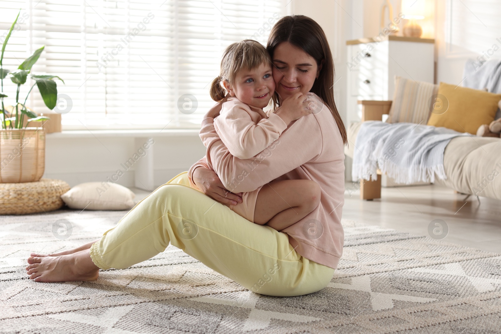 Happy mother and her cute daughter on floor at home Photo of Happy mother and her cute daughter on floor at home