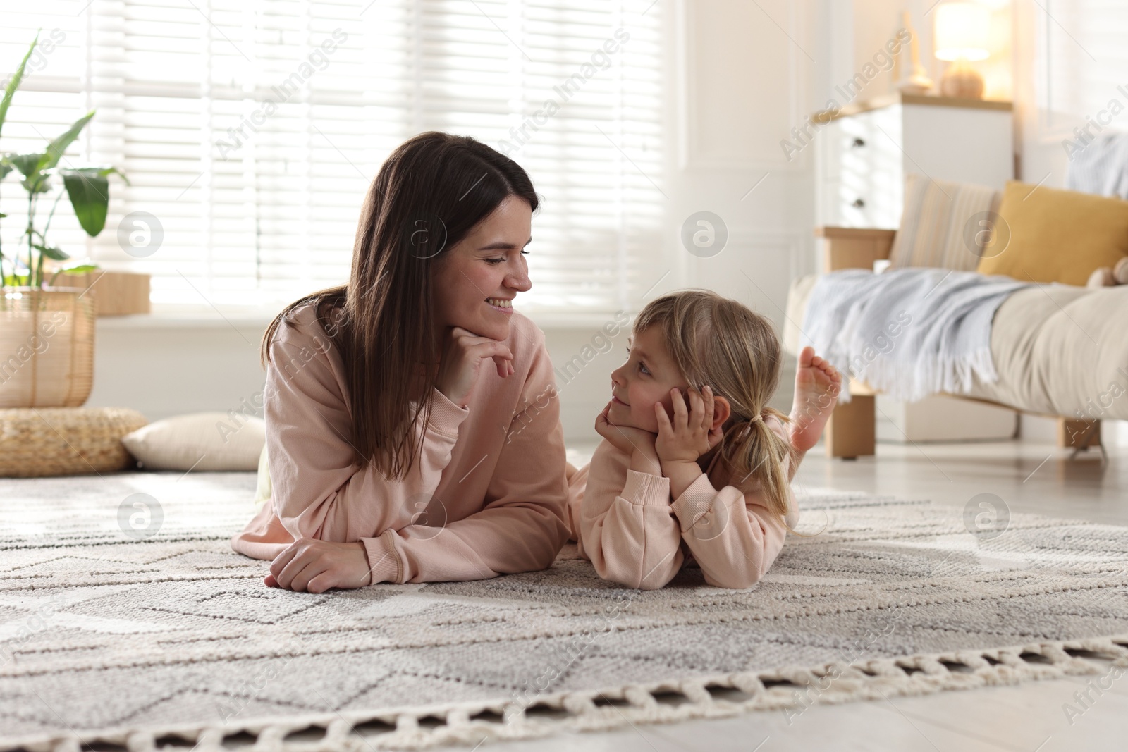 Happy mother and her cute daughter on floor at home Photo of Happy mother and her cute daughter on floor at home