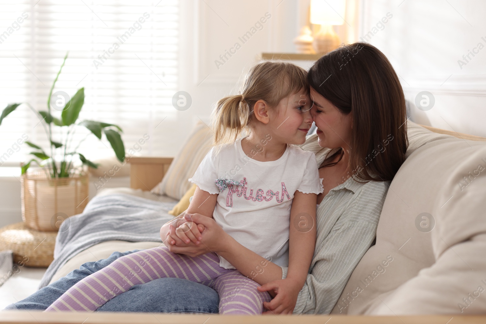 Happy mother and her cute daughter on sofa at home Photo of Happy mother and her cute daughter on sofa at home