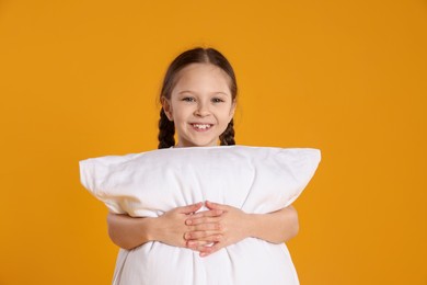 Photo of Cute girl with pillow on orange background