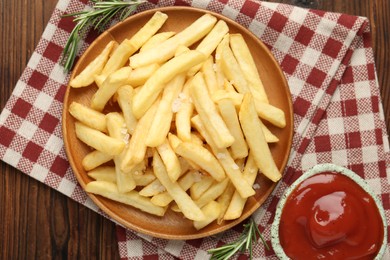 Photo of Tasty french fries served with ketchup and rosemary on wooden table, top view