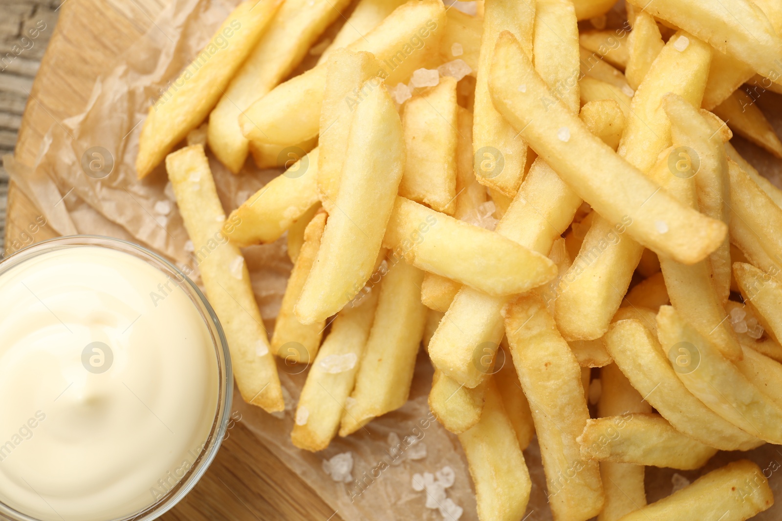 Tasty french fries served with mayonnaise on wooden table, top view Photo of Tasty french fries served with mayonnaise on wooden table, top view