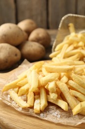 Photo of Tasty french fries on wooden table, closeup