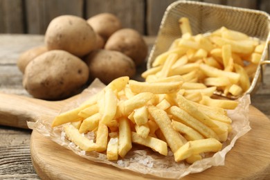 Photo of Tasty french fries on wooden table, closeup