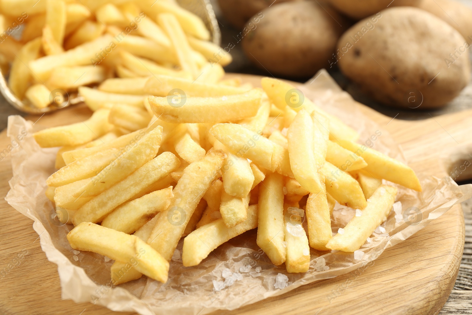 Tasty french fries on wooden table, closeup Photo of Tasty french fries on wooden table, closeup