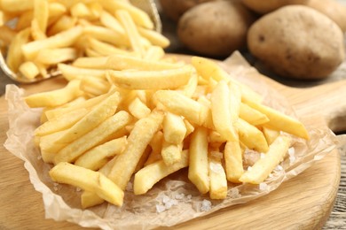 Photo of Tasty french fries on wooden table, closeup