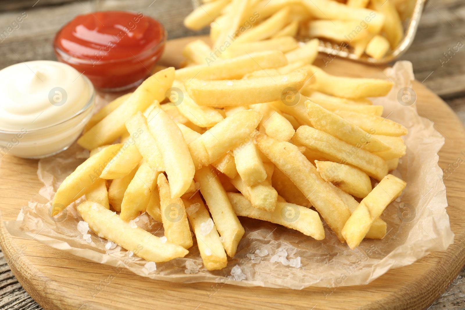 Tasty french fries served with sauces on wooden table, closeup Photo of Tasty french fries served with sauces on wooden table, closeup