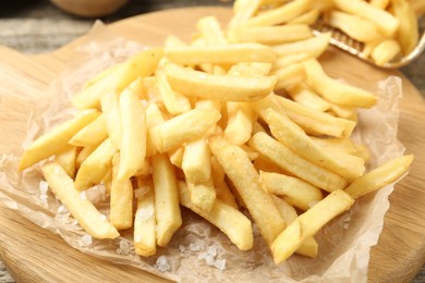 Photo of Tasty french fries on wooden table, closeup