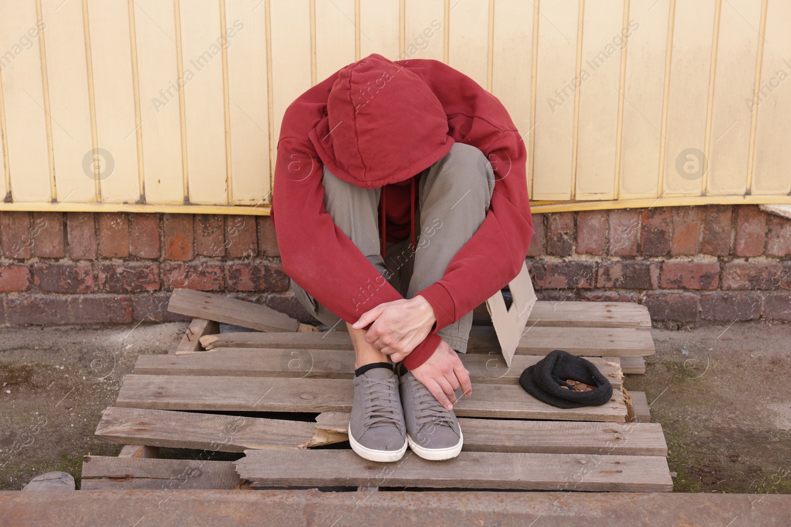 Photo of Homeless man and hat with coins on city street