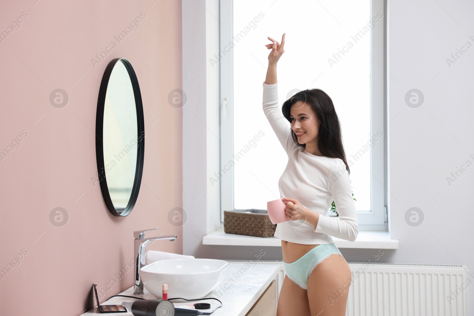 Woman wearing beautiful underwear with drink in bathroom Photo of Woman wearing beautiful underwear with drink in bathroom