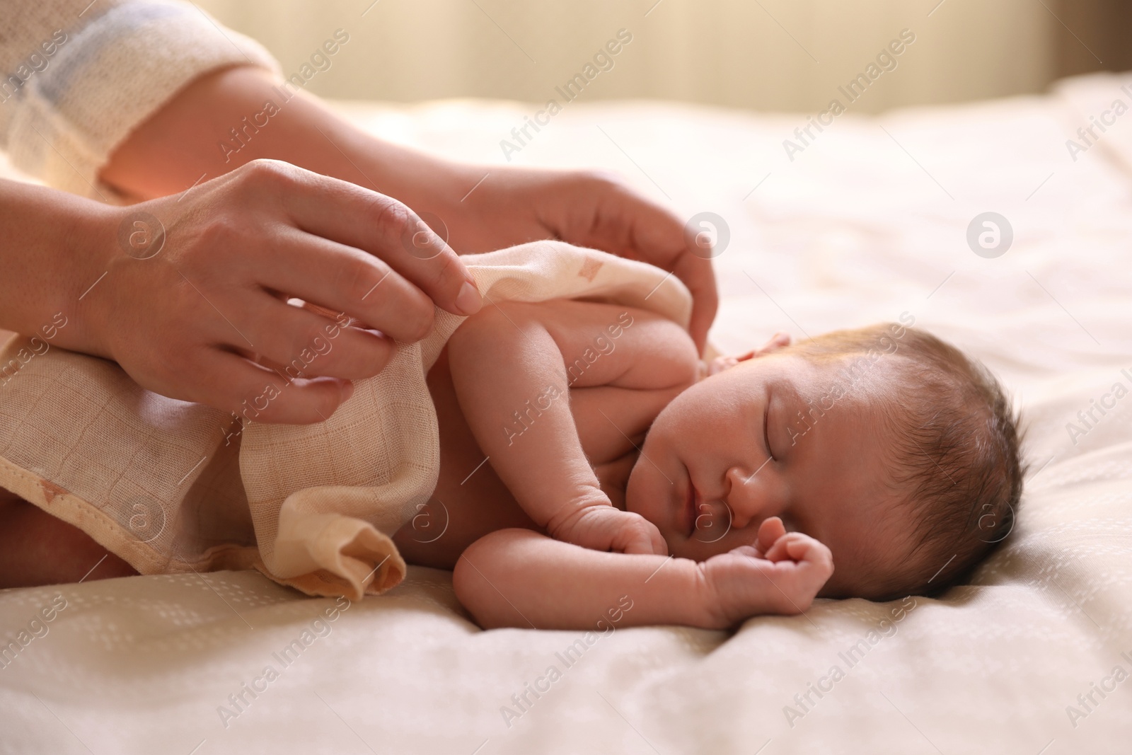 Bedtime. Mother covering her sleeping baby with blanket indoors, closeup Photo of Bedtime. Mother covering her sleeping baby with blanket indoors, closeup