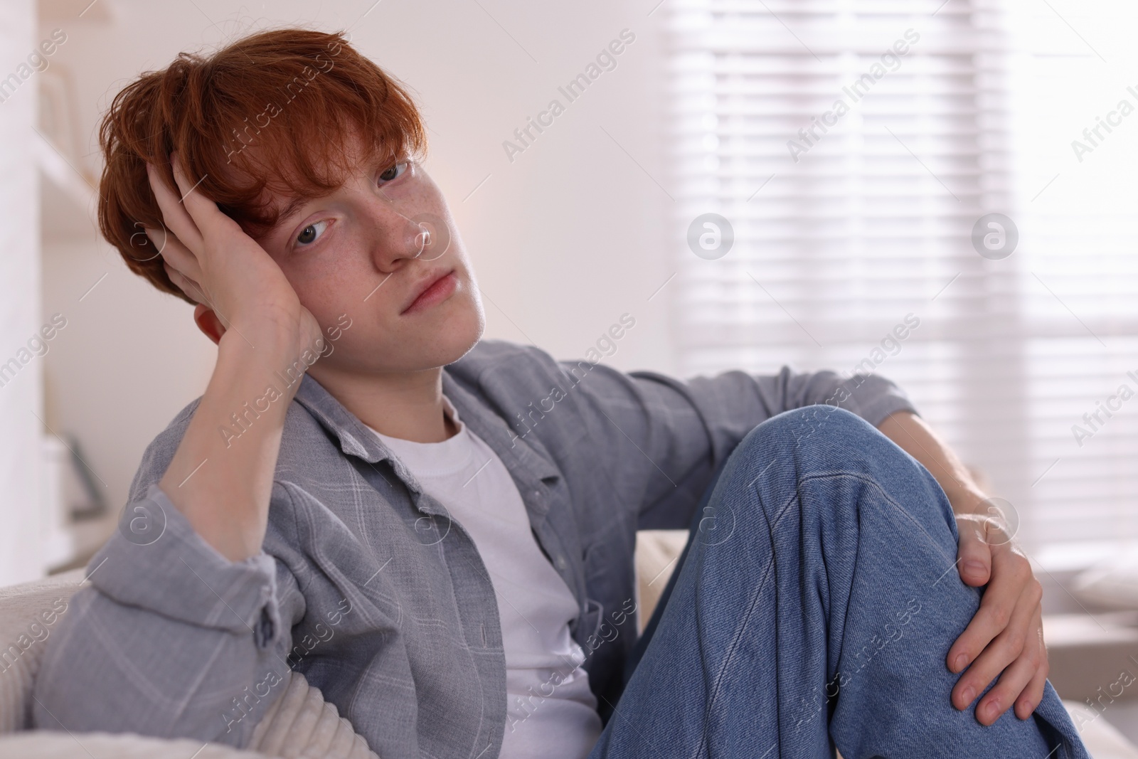Teen problems. Depressed teenage boy at home, space for text Photo of Teen problems. Depressed teenage boy at home, space for text