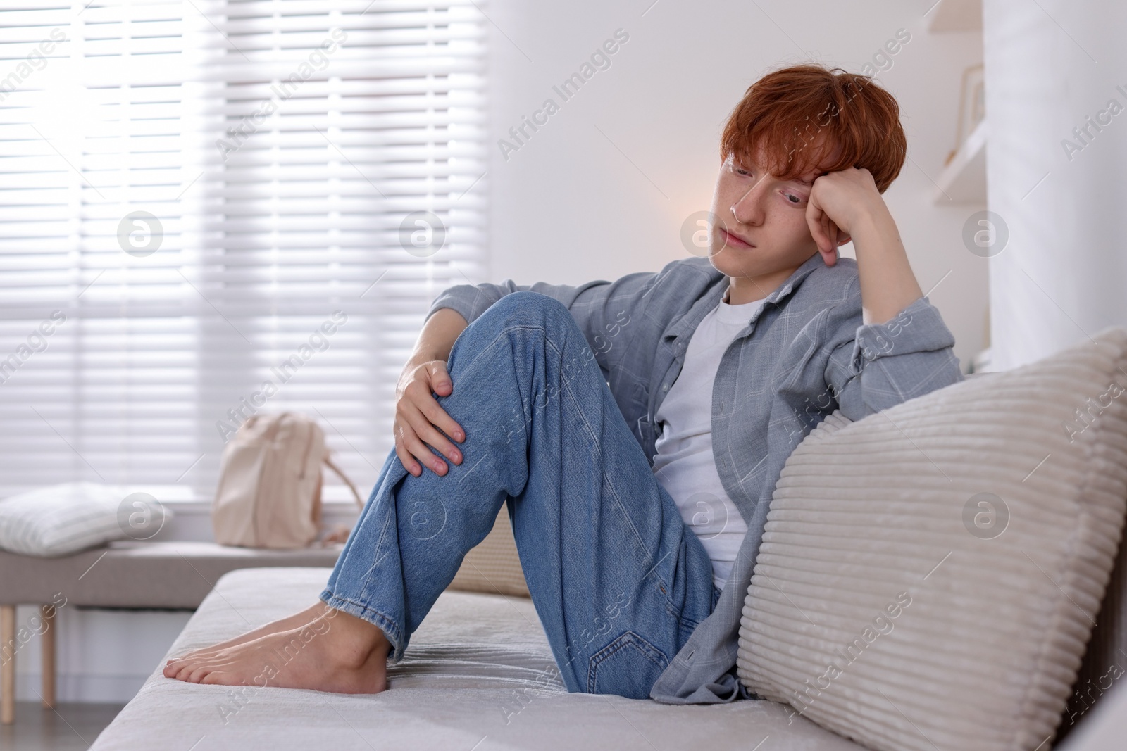 Teen problems. Depressed teenage boy on sofa at home, space for text Photo of Teen problems. Depressed teenage boy on sofa at home, space for text
