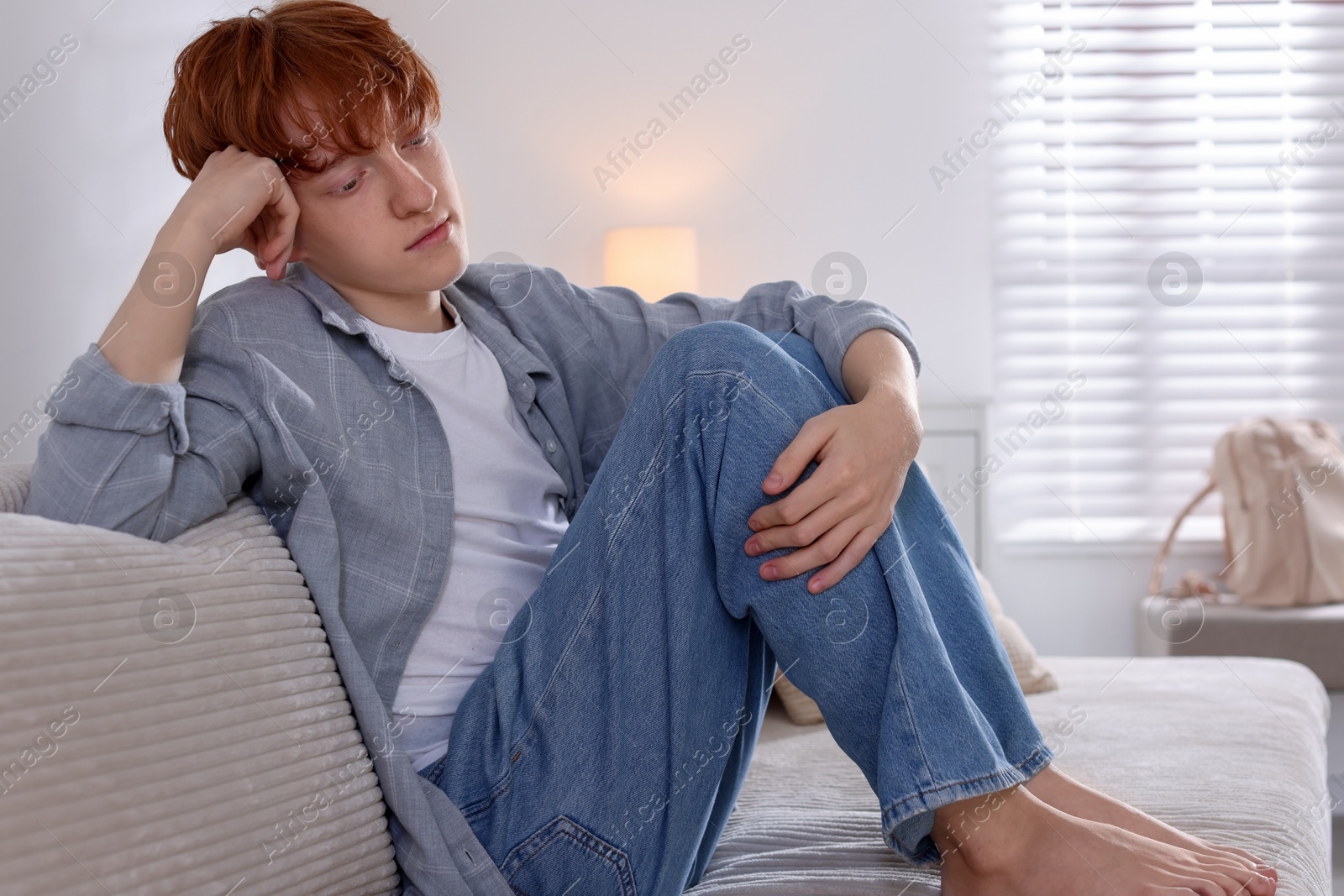 Teen problems. Depressed teenage boy on sofa at home Photo of Teen problems. Depressed teenage boy on sofa at home