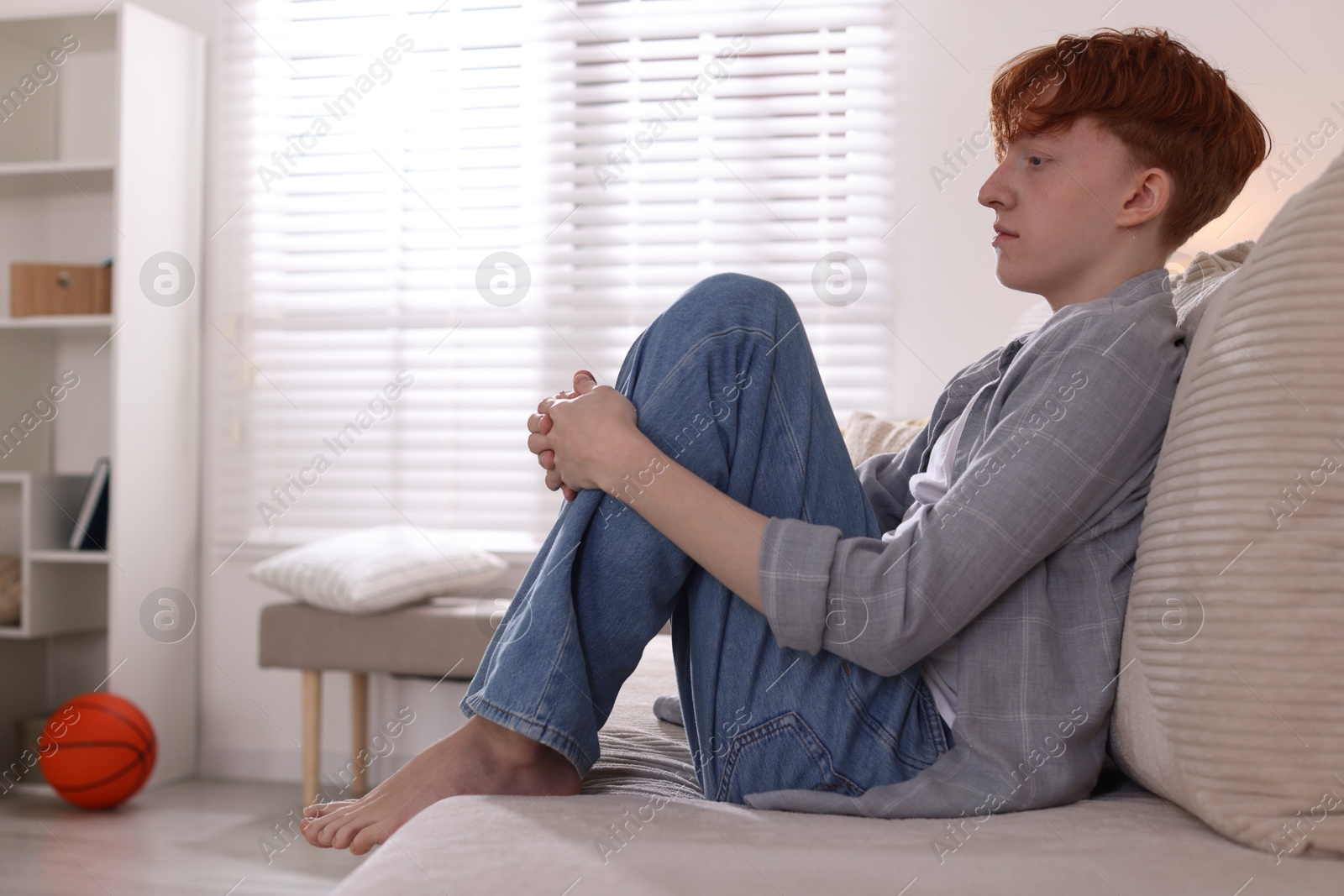 Teen problems. Depressed teenage boy on sofa at home, space for text Photo of Teen problems. Depressed teenage boy on sofa at home, space for text