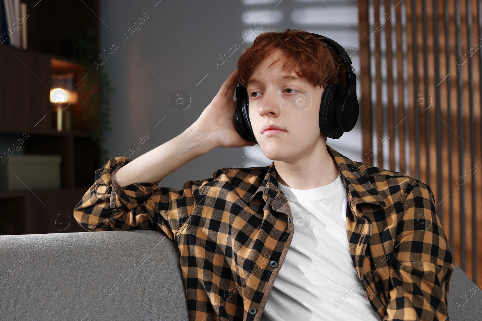 Teen problems. Depressed teenage boy listening to music at home Photo of Teen problems. Depressed teenage boy listening to music at home
