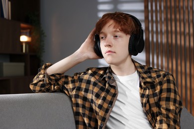 Photo of Teen problems. Depressed teenage boy listening to music at home