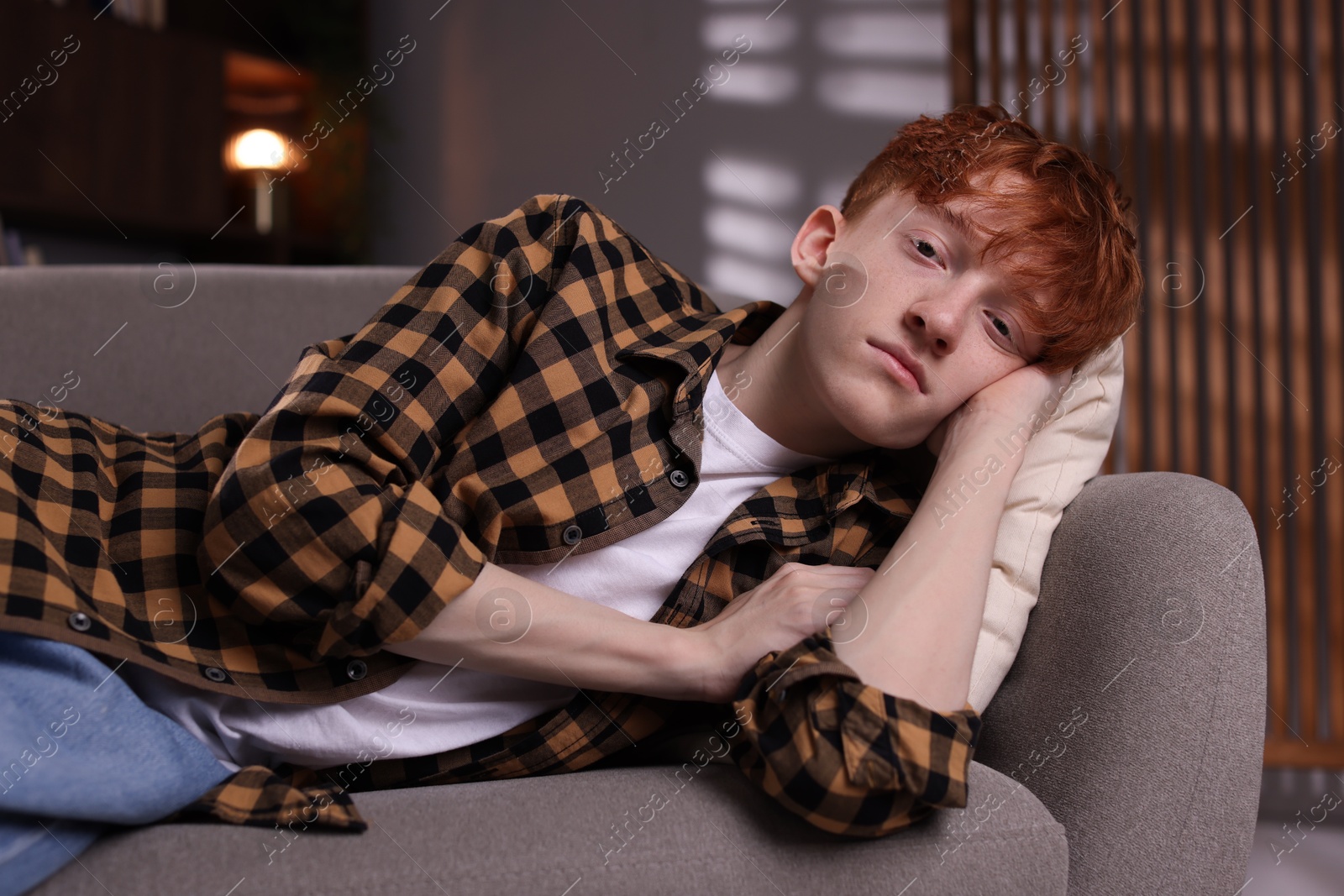 Teen problems. Depressed teenage boy lying on sofa at home Photo of Teen problems. Depressed teenage boy lying on sofa at home
