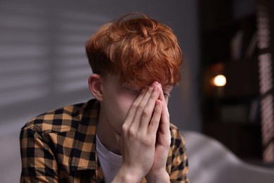 Photo of Teen problems. Depressed teenage boy at home