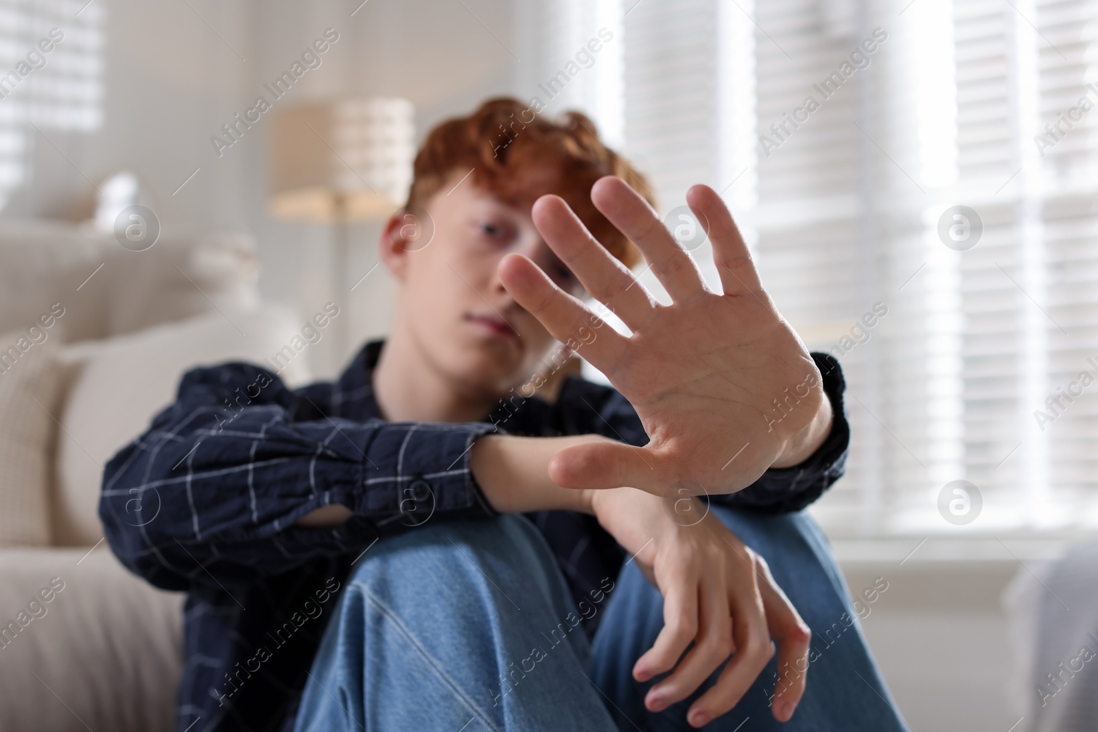 Teen problems. Depressed teenage boy at home, selective focus Photo of Teen problems. Depressed teenage boy at home, selective focus