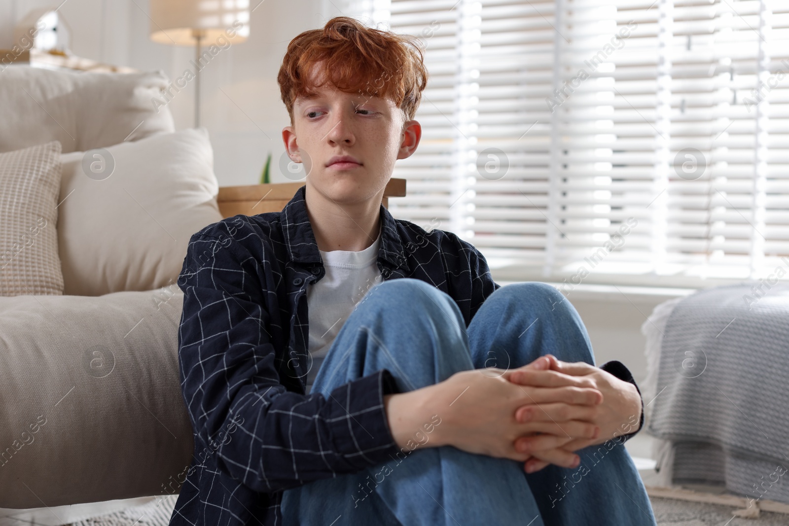 Teen problems. Depressed teenage boy on sofa at home Photo of Teen problems. Depressed teenage boy on sofa at home